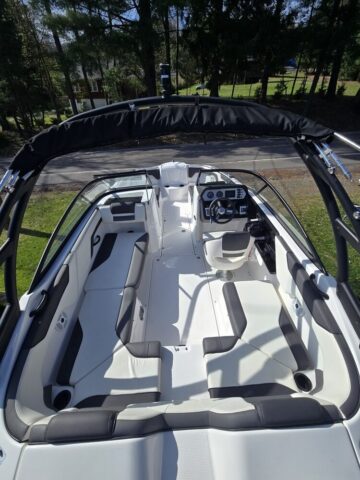 photo showing inteoror with white and gray seating, helm and driver's swivel chair